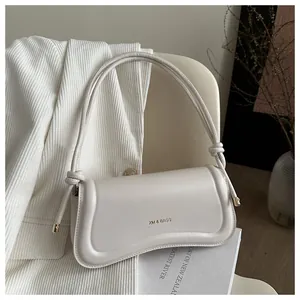 Close-up of off-white leather underarm bag featuring XM & BAGS logo and gold metal accents