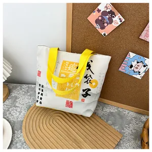 Detail of canvas tote bag featuring traditional Chinese calligraphy and yellow handles