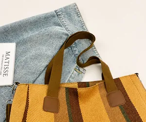 Detail showing comfortable reinforced brown shoulder strap and striped canvas fabric texture