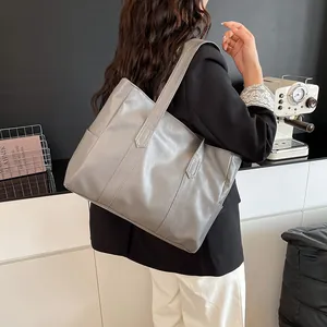 Λεπτομέρεια της γκρίζας τσάντας tote με γυαλιστερή υφή και πλαϊνή ραφή στο δέρμα