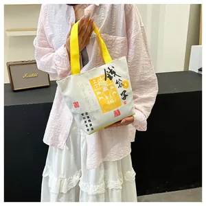 Detail of canvas tote bag with Chinese New Year print and yellow woven handle strap