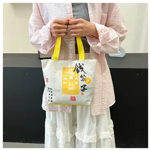 Close-up of canvas bucket bag with Chinese calligraphy and traditional yellow charms
