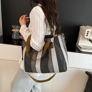 Detail of striped canvas tote bag showing thick cotton handles and spacious interior