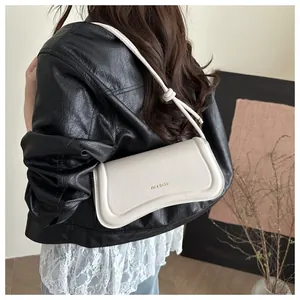 Detail of cream white leather shoulder bag with gold XM & BAGS logo and knot strap