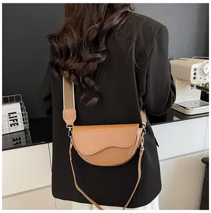 Détail d'un sac besace marron avec large bandoulière tissée vu de perspective arrière