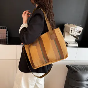 Lifestyle shot of large striped canvas tote bag with brown straps worn over the shoulder