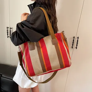 Detail of colorful striped canvas tote bag with brown straps and detachable shoulder strap