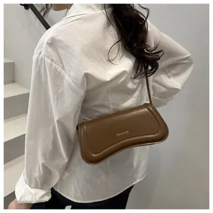 Detail of a vintage dark brown shoulder bag featuring the XM & BAGS gold logo and soft curves