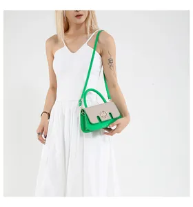 Dettaglio borsa in pelle verde con patta beige testurizzata e finiture dorate a M