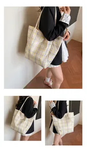 Detail of yellow and grey plaid canvas tote bag showing large capacity and textile texture