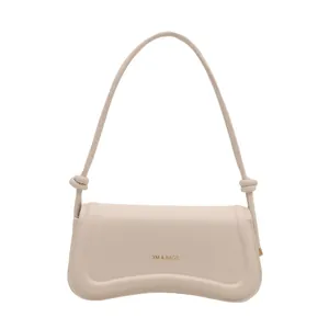 Minimalist cream white crossbody bag with gold logo and curved base design