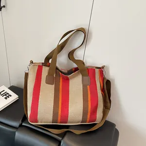 Detail of striped canvas tote bag with adjustable shoulder strap and double handles
