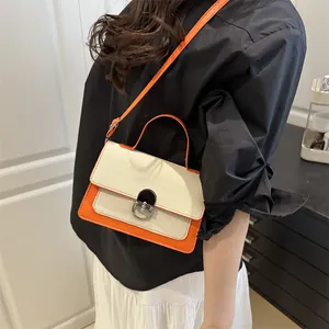 Chic orange and cream canvas patchwork crossbody bag with silver rotating lock closure