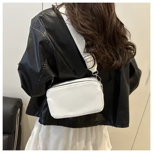 Close-up of white rectangular camera bag with adjustable wide strap on model