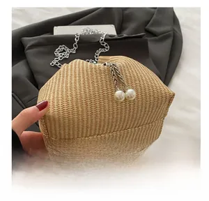 Detail of cream woven bucket bag with silver chain strap and large pearl charms