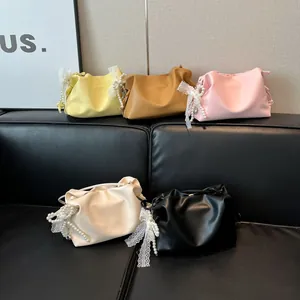 Modische süße Wolken-Beuteltaschen in fünf Farben mit Spitzenschleifen auf Sofa