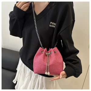 Detail of pink woven mini bucket bag with silver chain and white pearl drawstring accents