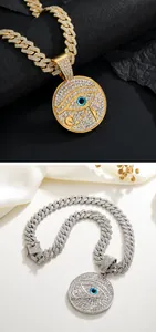 Detail of hip hop Eye of Horus pendant with iced-out crystals on gold and silver Cuban chains