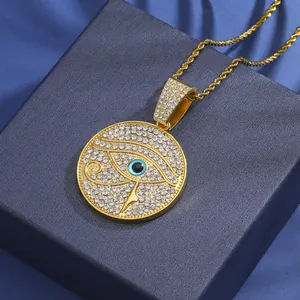Close-up of iced-out gold Eye of Horus pendant on luxury blue textured gift box