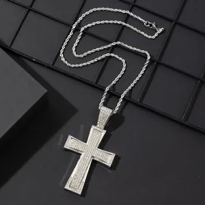 Macro detail of iced-out cross pendant with sparkling stones on silver rope chain