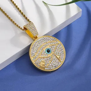 Macro detail of gold Eye of Horus pendant necklace featuring paved crystals on silk background