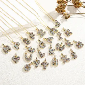 Macro shot of 26 colorful zircon alphabet pendants with gold-plated chains and floral decor