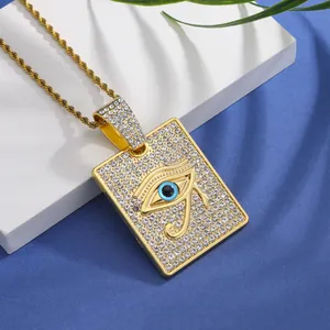 Gros plan du collier hip hop doré avec pendentif carré serti de strass et œil de Horus