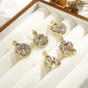 Detailed shot of gold pendants with colorful micro-pave cubic zirconia letter charms