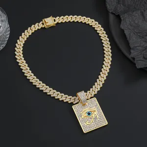 Gros plan du pendentif Oeil d'Horus doré avec chaîne cubaine en zircon sur fond noir