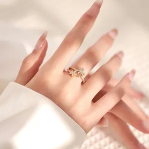 Detail of 18K gold plated double band ring with sparkling zircon butterfly accents