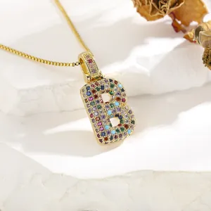 Macro view of gold letter B pendant necklace with colorful micro-set cubic zirconia