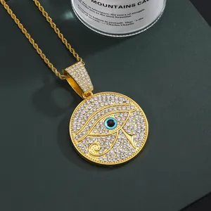Detail of gold hip hop pendant with Horus eye design and sparkling pavé crystals