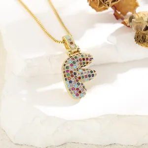 Close-up of golden letter F pendant necklace with colorful cubic zirconia stones
