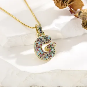 Detailed shot of gold letter G necklace pendant with colorful pavé micro zircons