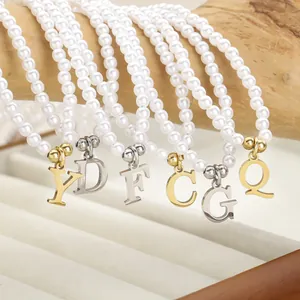 Elegante Perlenketten mit Gold- und Silberbuchstaben auf einem Holzdisplayständer