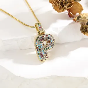Macro view of gold letter P pendant with multi-colored zircons on a box chain