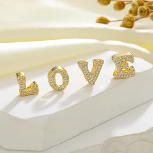 Detail of LOVE gold charms with micro-paved zircons for DIY jewelry making