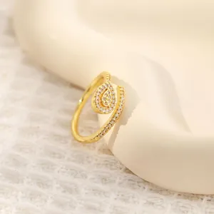 Macro view of teardrop 18K gold plated ring with micro-pave zircons on ceramic tray