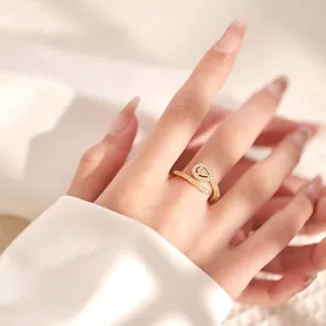 Detail view of 18K gold plated wrap ring with pear-shaped cubic zirconia on model finger