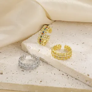 Detail of adjustable gold and silver rings with sparkling zircon inlay and wave texture