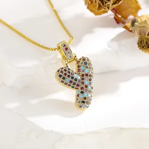 Macro shot of 3D letter Y pendant necklace with colorful cubic zirconia and gold chain
