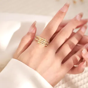 Detail of 18K gold plated multi-layer crisscross ring with zircons on model hand