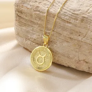 Dettaglio di un ciondolo segno zodiacale Toro in oro con una sottile collana a maglia box