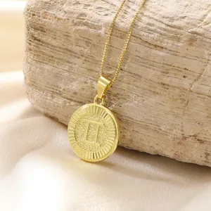 Dettaglio del ciondolo a moneta Gemini in oro con numero romano II su catena veneziana