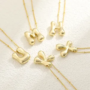 Detailed view of 18K gold plated puffy letter pendants M H U K X with mirror finish