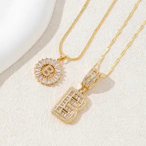 Detailed close-up of gold plated letter B pendants with sparkling zircon stones on stone