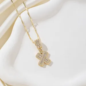 Vue détaillée du collier doré avec pendentif lettre X serti de zircons sur soie blanche