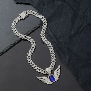 Detail of hip hop Cuban link chain with angel wings pendant and blue center stone