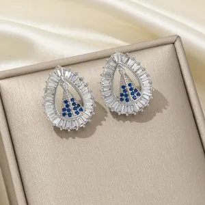 Détail de boucles d'oreilles goutte avec saphir bleu et cristaux de zircone baguette