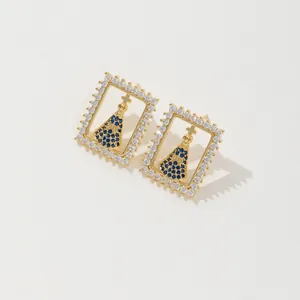 Détail de boucles d'oreilles dorées avec pendentif saphir bleu Nossa Senhora Aparecida